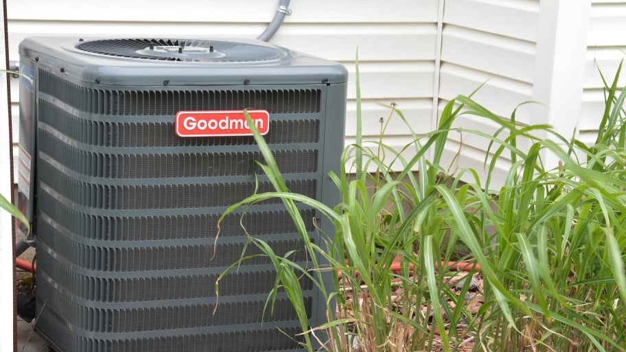An air conditioning unit sits outside a home.